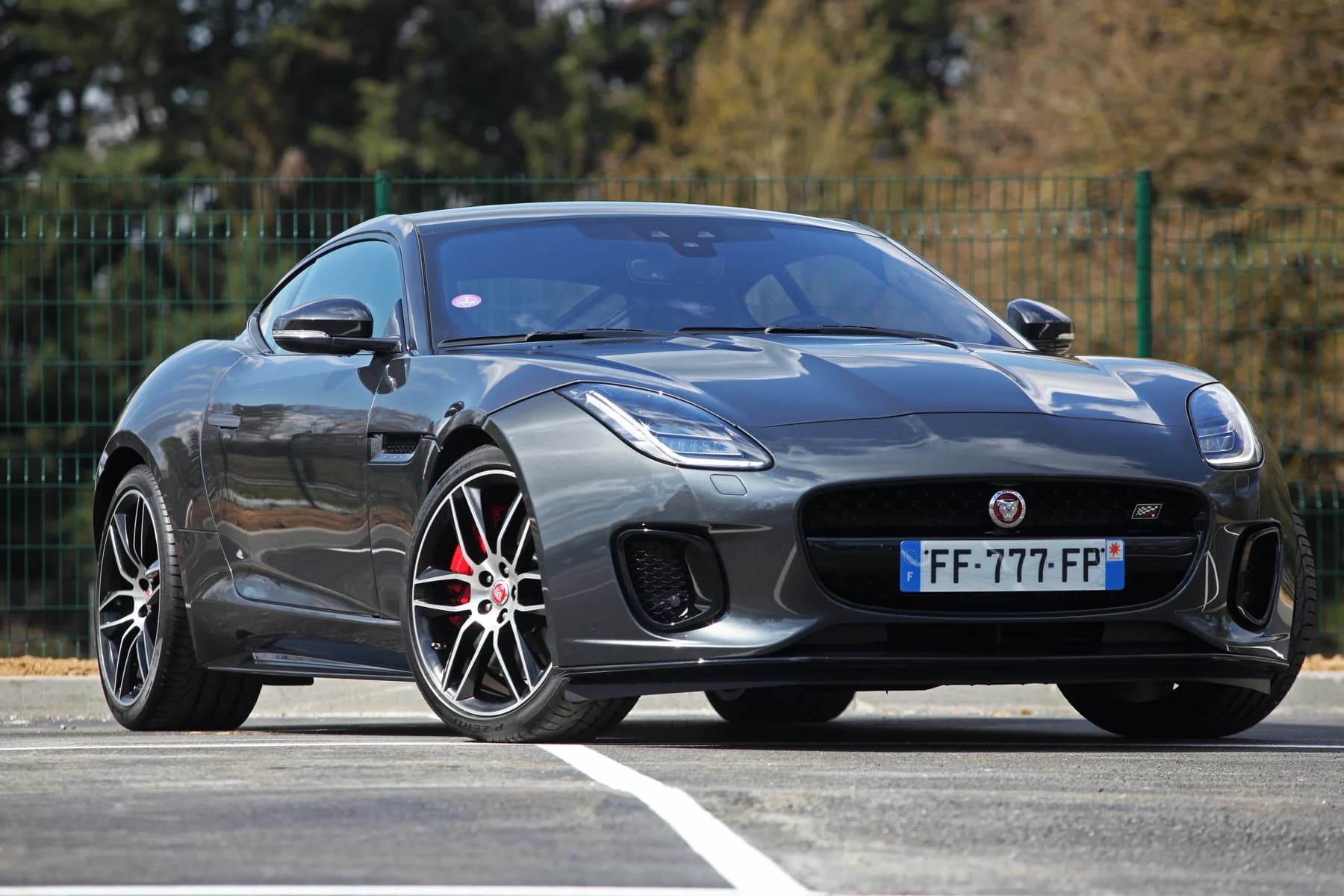 Unprepared gray Jaguar F-Type photographed outdoors with its license plate visible